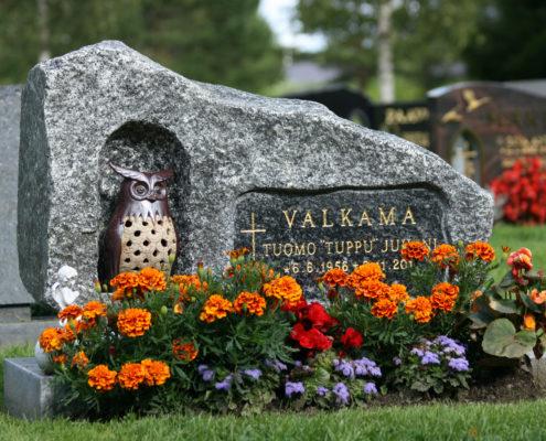 Tähän luonnonkivestä tehtyyn hautakiveen on tehty louhittu pesä pöllölle. Nimitila on upotettu ja hiottu